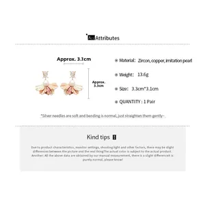 Detail view of flower earrings with pink petals, imitation pearls and square zircon studs