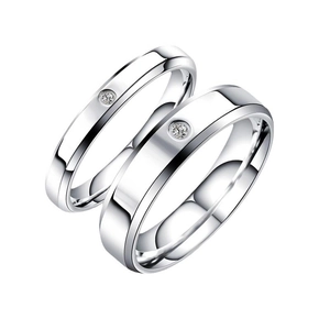 Detailed view of polished silver titanium steel couple rings with single cubic zirconia stones