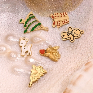 Macro shot of 14K gold plated Christmas charms with colorful enamel drip details