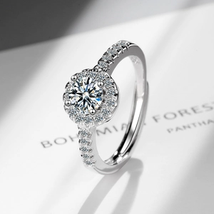 Elegant halo engagement ring with a round center stone and pave diamond band on white background