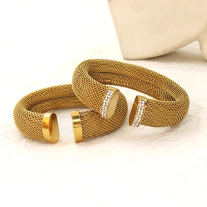 Chic gold mesh cuff bracelets with sparkling zircon accents on light textured background