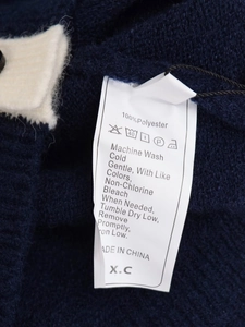 Close-up of garment wash label showing 100% polyester material and care instructions