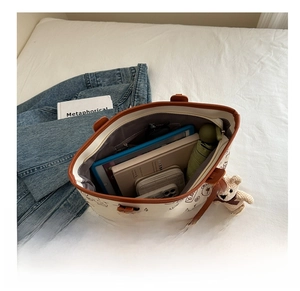 Top-down view of a spacious canvas tote bag interior showing organized daily essentials
