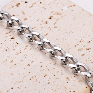Polished silver stainless steel 9.5mm square twist chain on a natural stone surface