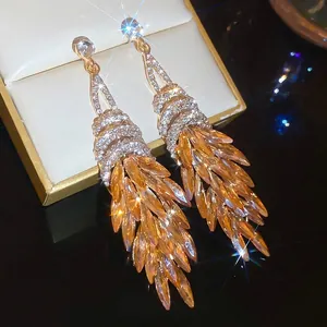 Elegante goldene Ohrhänger mit bernsteinfarbenen Kristallen und funkelnden Strasssteinen
