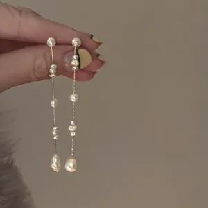 Detailed macro view of French vintage freshwater pearl tassel earrings with gold chains