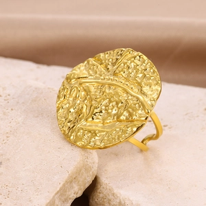 Macro detail of golden geometric ring with hammered texture on natural stone