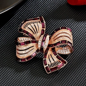 Macro shot of elegant bow brooch featuring purple rectangular gems and shiny crystals