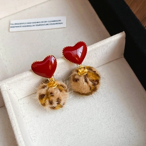 Detail shot of heart leopard print faux fur earrings in a white jewelry gift box