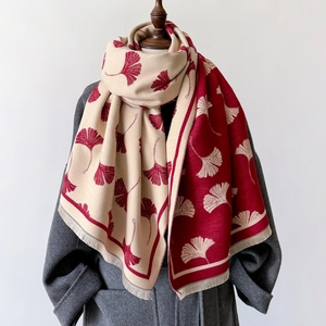 Knitted cashmere-feel scarf with red and beige ginkgo leaf pattern and fringe edges
