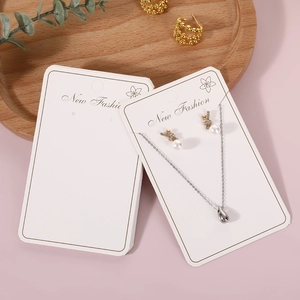 Silver teardrop necklace and gold pearl earrings set on New Fashion jewelry display card