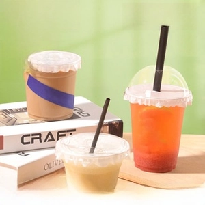 Detailed view of clear PET plastic cups with dome lids and straws for cold coffee and tea
