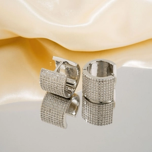 Boucles d'oreilles créoles en U pavées d'argent sur soie jaune avec reflet miroir