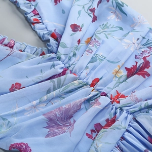 Nahaufnahme von Blumenkleid mit Rüschen und plissierten Details auf Chiffon-Stoff