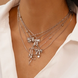Détail d'un collier argenté multicouche à nœuds avec chaînes délicates sur un mannequin