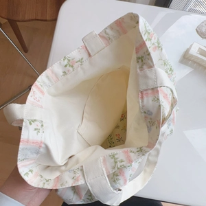 Vista ravvicinata dell'interno della borsa di tela con motivi floreali e tasca aperta