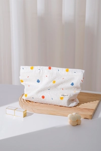 Artistic makeup bag with abstract patterns on a wavy wooden tray by a sunny window