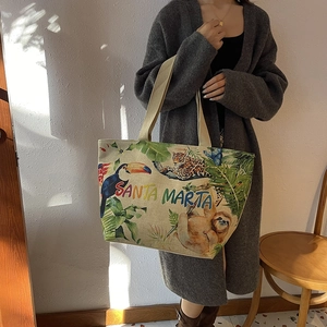 Close-up of beige linen tote bag featuring tropical toucan and leopard print design