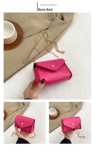 Detail of rose red crocodile textured mini bag with gold chain and round buckle clasp