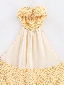 Dettaglio ravvicinato dello scollo a torsione e del tessuto in chiffon floreale giallo