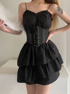 Detail of elegant black corset belt with metallic eyelets and lace-up on ruffled dress