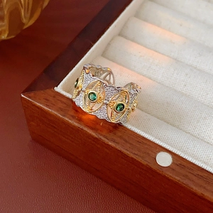 Dettaglio di un anello largo stile barocco con gemme verdi e micro diamanti lucenti