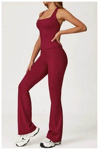 Detail view of burgundy yoga leggings with functional side pockets and flared hem finish