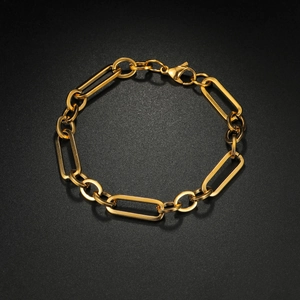 Golden stainless steel paperclip chain bracelet with lobster clasp on black background