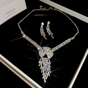 Detailed view of luxury crystal tassel necklace and earrings set in a black gift box