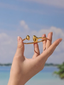 Gros plan du bracelet triangle en or 18 carats avec détails en forme de cœur poli