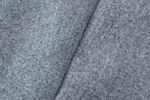 Macro view of mid-grey wool blend fabric texture with soft diagonal folds and felt finish
