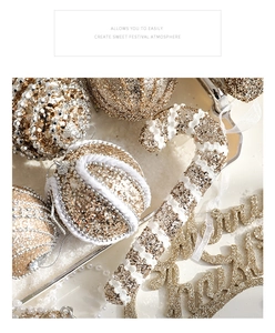 Close-up of golden Christmas ornaments including glitter balls and candy canes