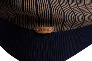 Detail of navy ribbed hem and coffee stripes with leather logo on men's knit sweater
