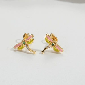 Macro shot of dragonfly stud earrings with pink and green enamel wings and zircon stones