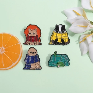 Lot de quatre broches en émail représentant un renard, un blaireau, un hibou et une tortue