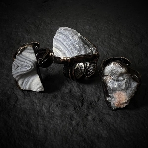 Macro view of three vintage bronze feathered rings with natural druzy agate stones