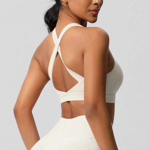 Detail van witte sportbeha met gekruiste rug en yoga-legging met hoge taille van achteren