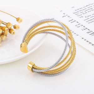 Detail of multi-layer C-shaped steel wire braided bracelet in gold and silver finish