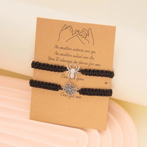 Detail of two woven spider web bracelets on gift card with emotional quote