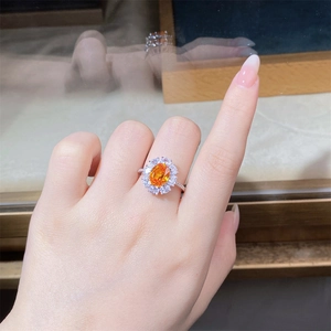 Close-up of elegant S925 silver ring featuring an oval orange gemstone in flower halo