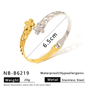 Macro view of two-tone stainless steel flower bracelet showing 6.5cm diameter and weight