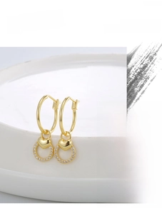 Detailed macro view of gold heart drop earrings with sparkling cubic zirconia crystals
