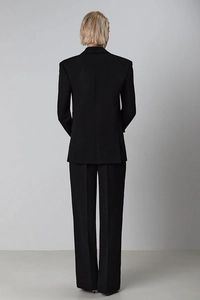 Back view of a sleek black women's suit set showing slim fit blazer and trousers