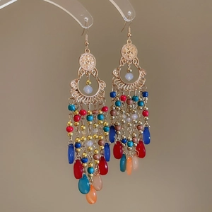 Detailed close-up of bohemian chandelier earrings with colorful beads and gold tassels