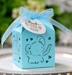 Close-up of sky blue baby shower favor box with elephant hollow design and ribbon