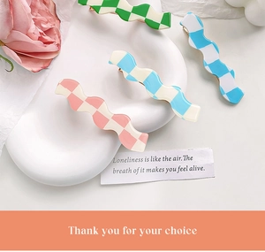 Detail shot of wavy checkerboard hair clips in green, blue and pink pastel colors