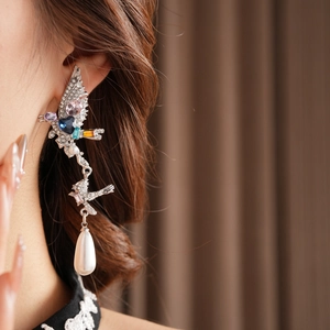 Vue rapprochée de boucles d'oreilles oiseaux vintage avec cristaux et perles