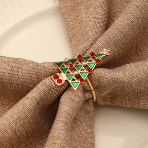 Rond de serviette sapin de Noël avec émail vert et strass rouges sur lin beige