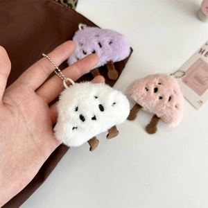 Dettaglio di morbidi ciondoli in peluche a nuvola con gambe lunghe in bianco, rosa e viola