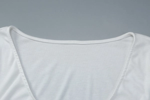 Détail du col en U blanc avec boutons sur une robe moulante à manches longues